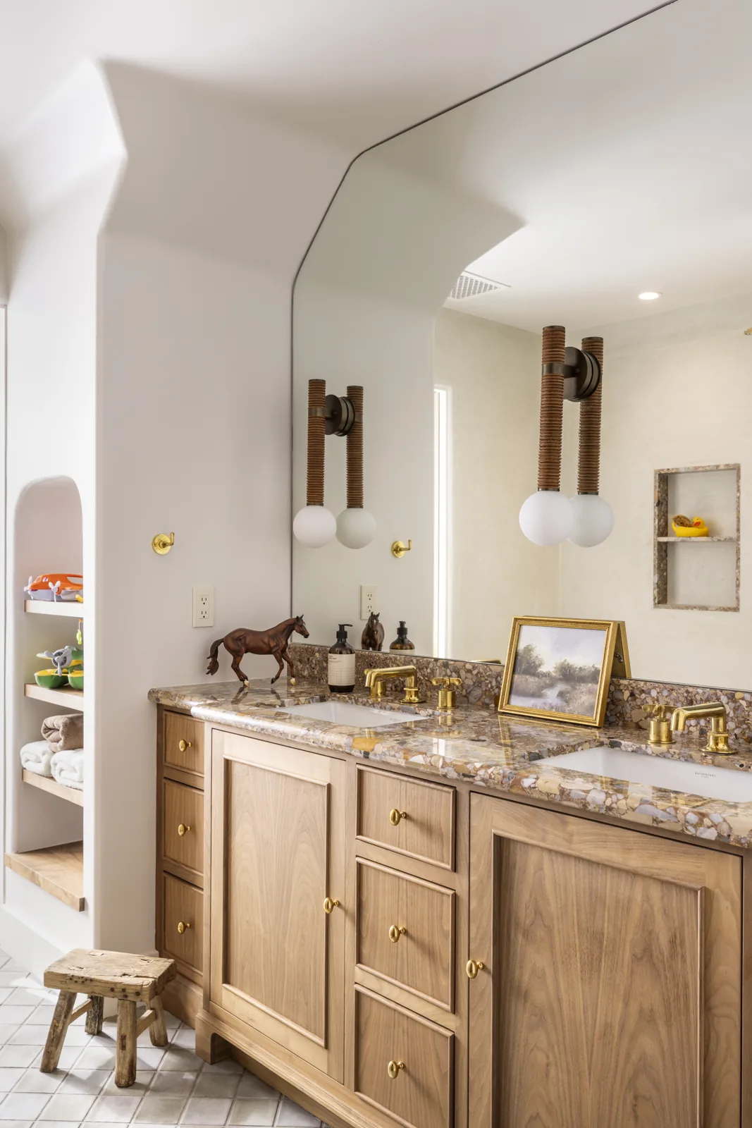 Double bathroom vanity with stone counters, wood cabinetry, and globe sconces at Adobe Canyon Farmhouse