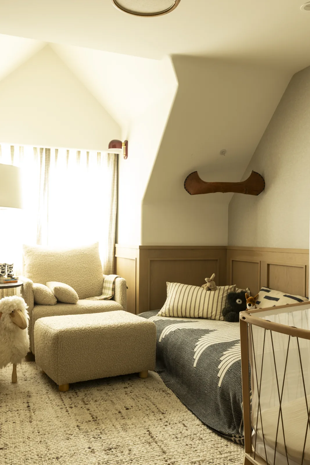 Nursery with paneled walls, a daybed, and a textured lounge chair at Adobe Canyon Farmhouse