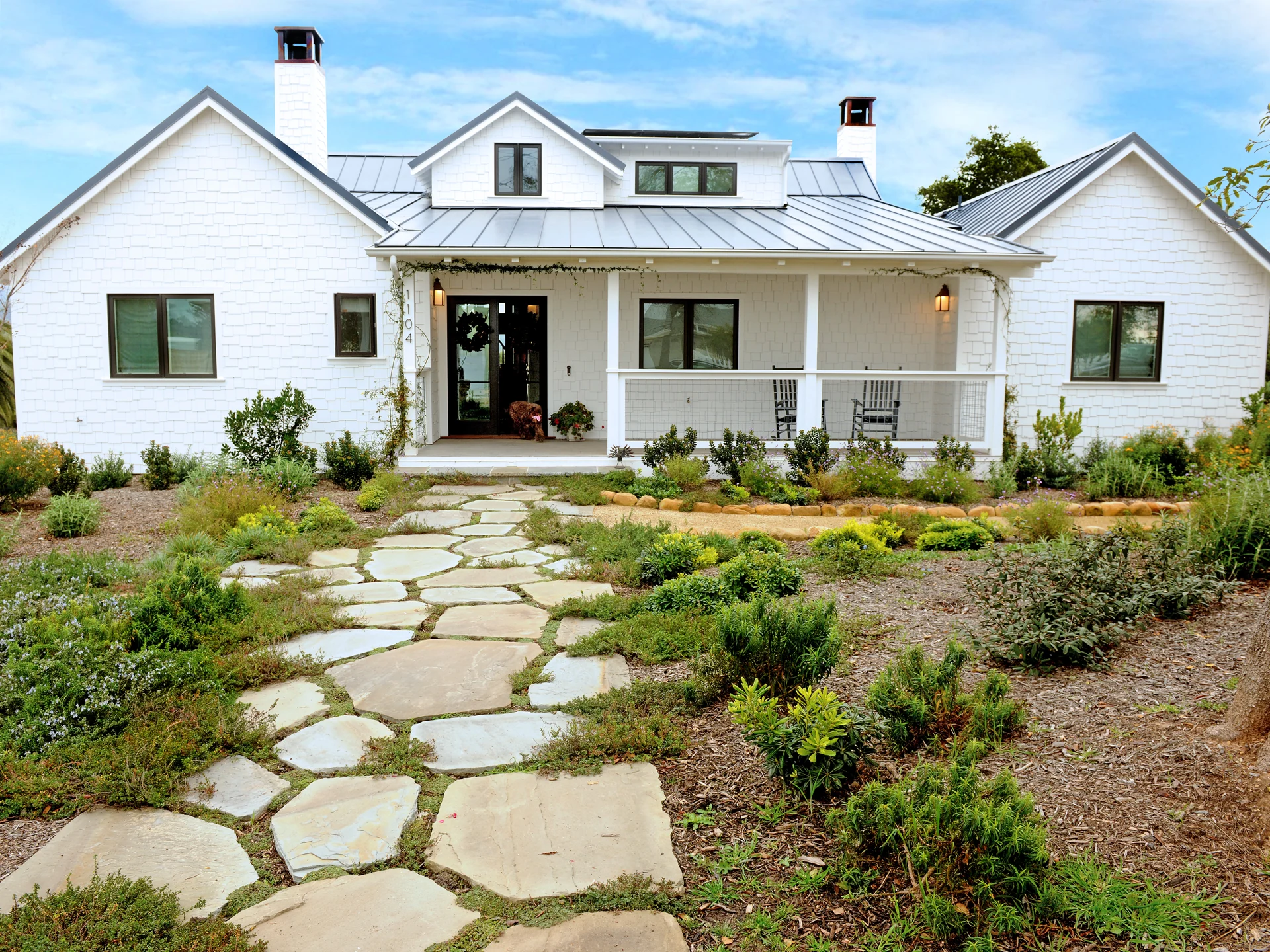French Country In Goleta front exterior with a covered porch and landscaped entry