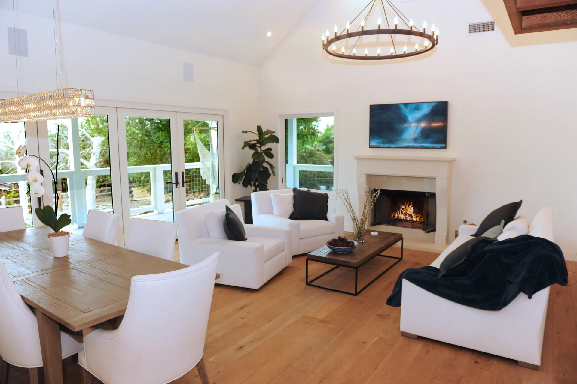 French Country In Goleta living and dining room with a fireplace and doors to the porch