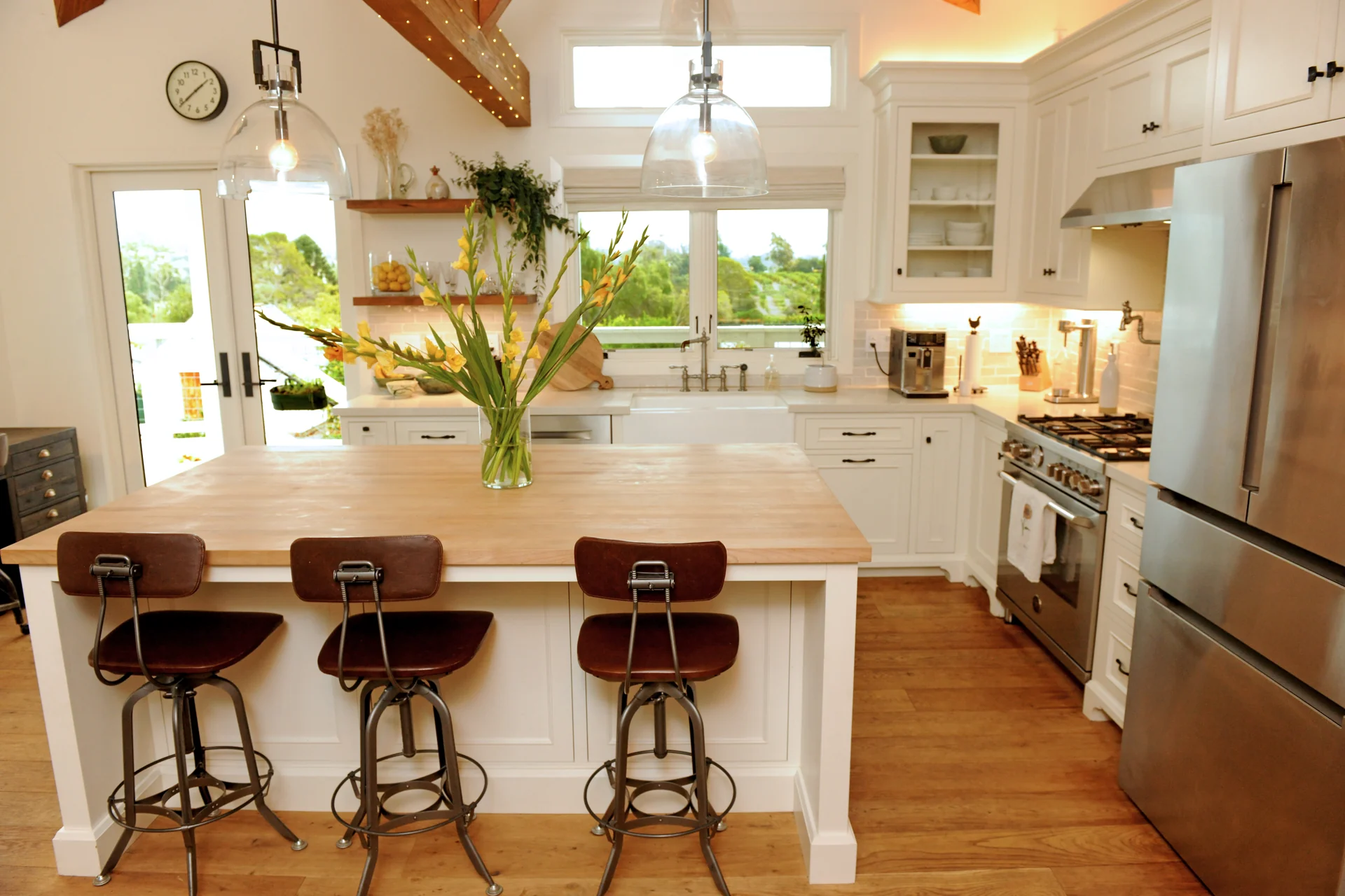 French Country In Goleta kitchen with a wood island and glass pendant lighting
