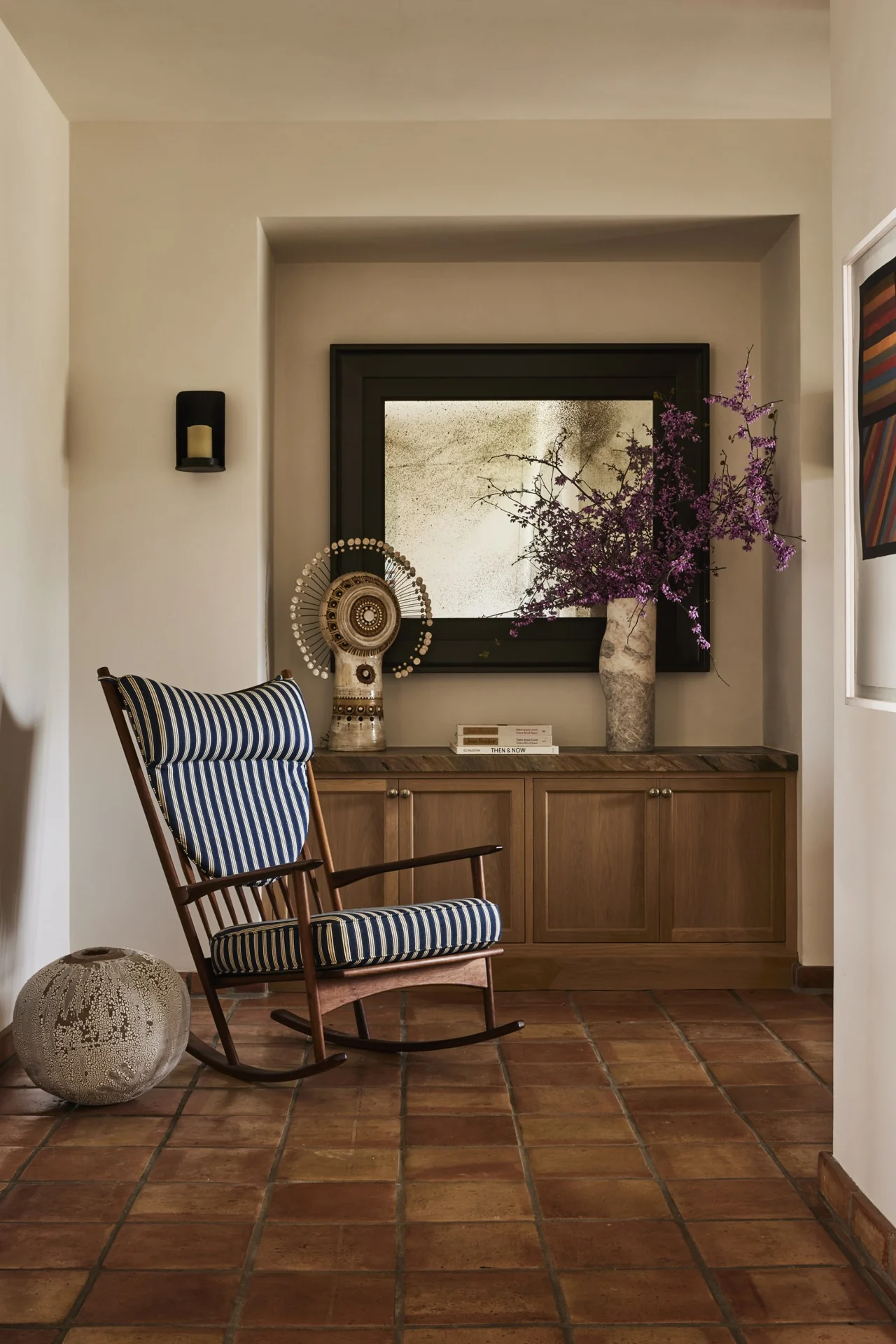 Seating nook with a striped rocking chair and built-in cabinet