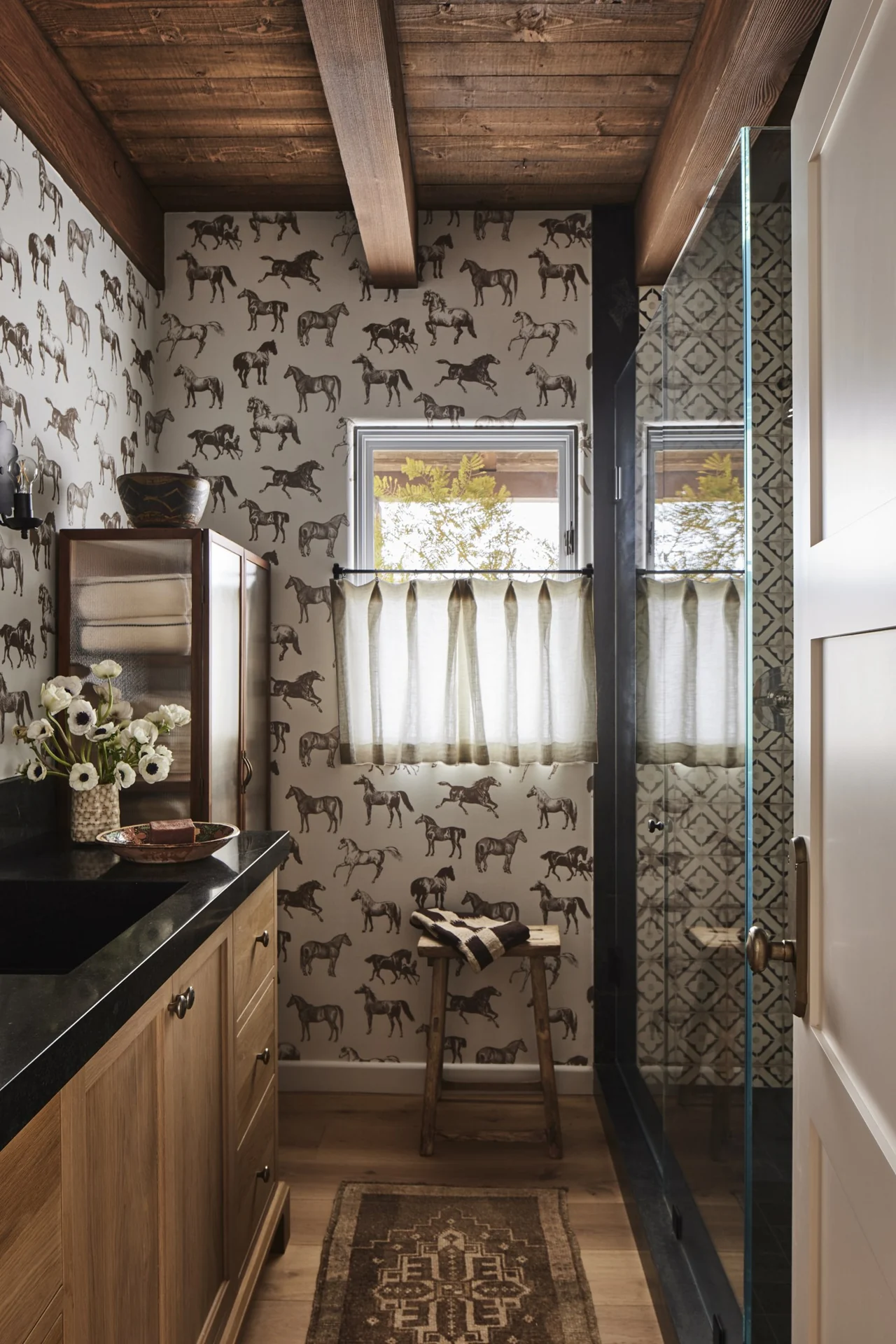 Bathroom with equestrian wallpaper and patterned shower tile
