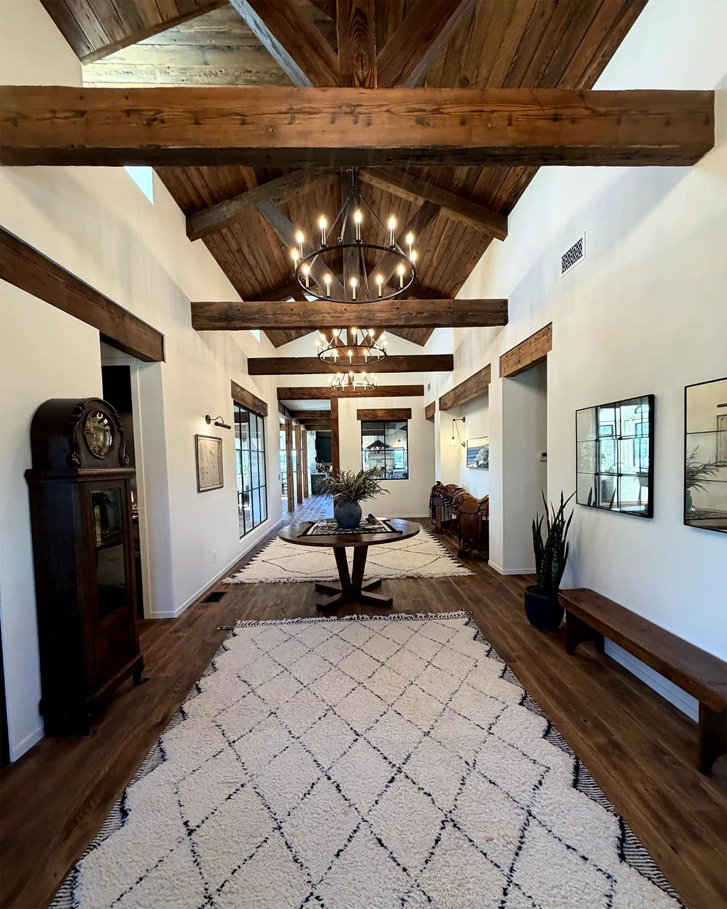 Entry hall with exposed timber ceiling and chandeliers