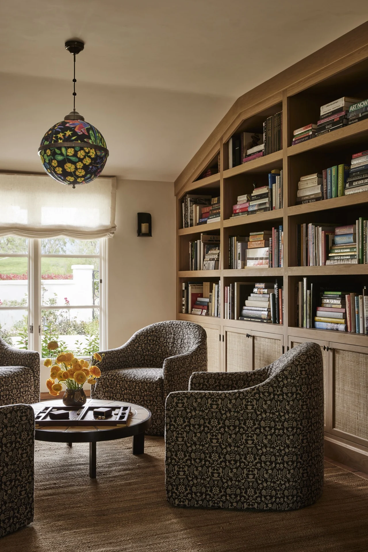 Library with custom cabinetry and patterned armchairs